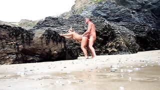Un couple âgé mature fait l'amour sur une plage publique